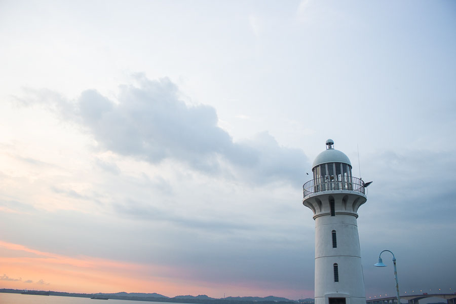 Raffles Marina Lighthouse with the sun setting on the horizon