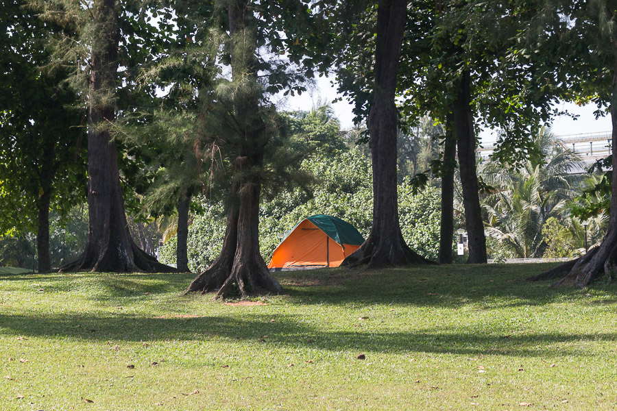 An orange tent in between some trees at west coast park