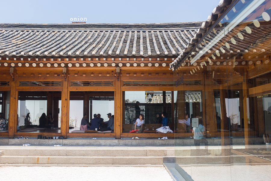 interior of cafe onion anguk with customers sitting along the porch