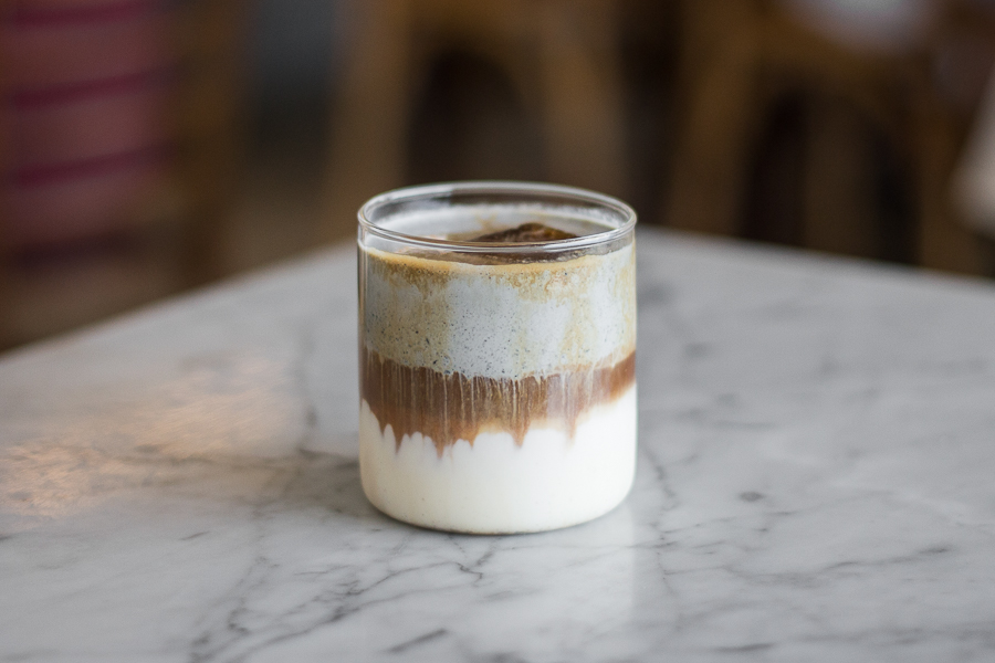 a glass cup with black sesame cream and coffee