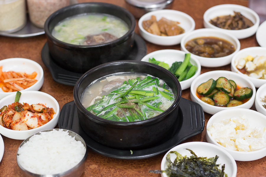 Kim's Family Korean Restaurant Beauty World with A bowl of gukbap and oxtail soup on the table surrounded by the different side dishes