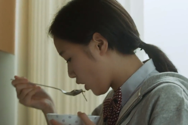 Woman trying a spoonful of korean food