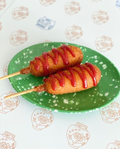 Cheesy Corndogs drizzled with ketchup from Kong Cafe on a retro looking green colour plate