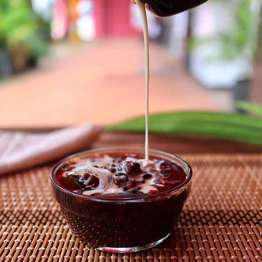 Cong Ngot - Black Sweetness - A bowl of black bean dessert with coconut milk drizzled over it