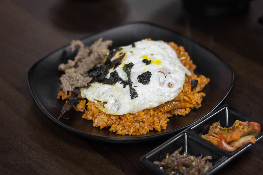 A plate of kimchi fried rice with beef and a fried egg