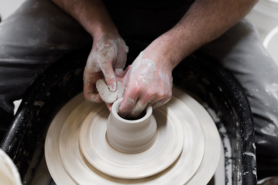 Someone using the pottery throwing wheel