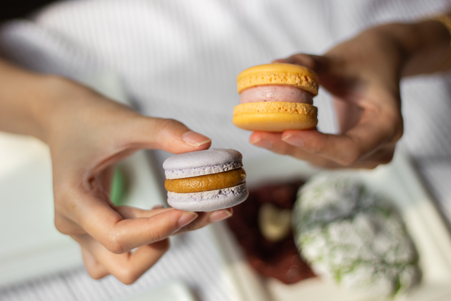 A Person holding a piece of Macaron on each hand