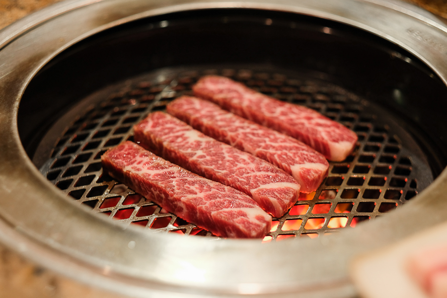 Beef Striploin being grilled over charcoal fire at Seoul Restaurant Regent Hotel