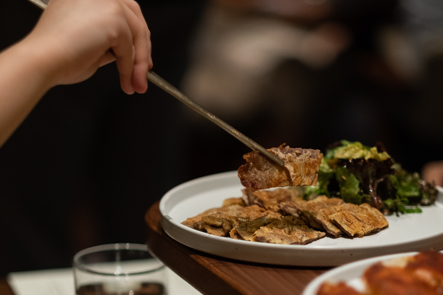 Picking up Yuk Jeon using chopsticks at ANJU Restaurant Singapore