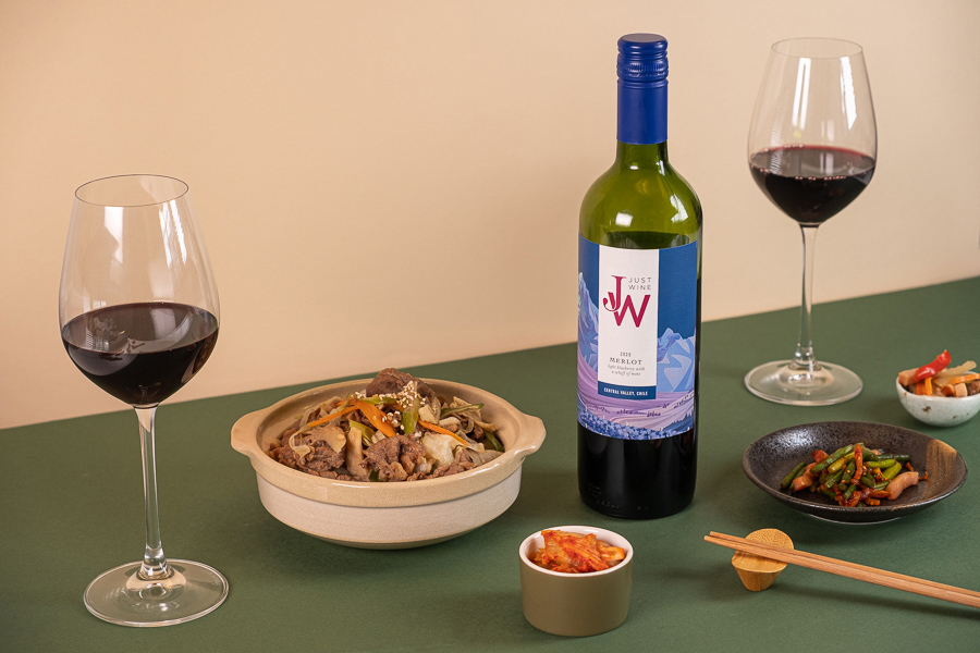 Just Wine's Merlot with two wine glasses and a pot of bulgogi