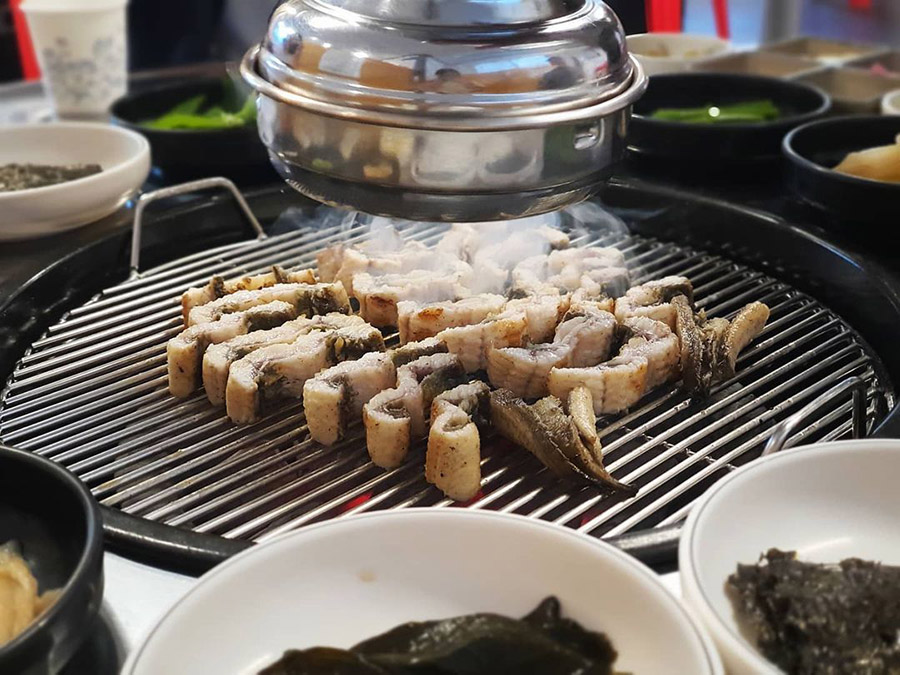 Grilling freshwater eel on charcoal fire in Korea