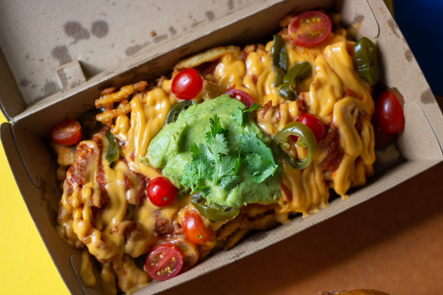 Loaded Gangnum Nachos Fries topped with Jalapenos, Cherry Tomatoes and Tomato Salsa
