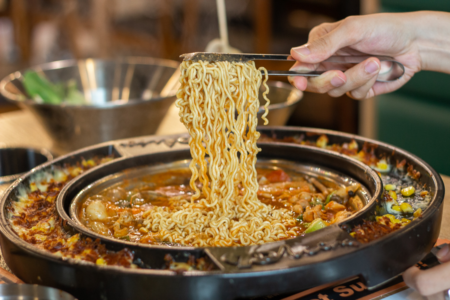 Using tongs to pull up Ramyeon