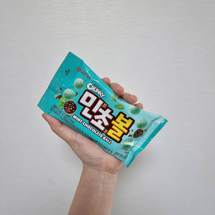 Someone holding a packet of Lotte Crunky Mint Choco Ball