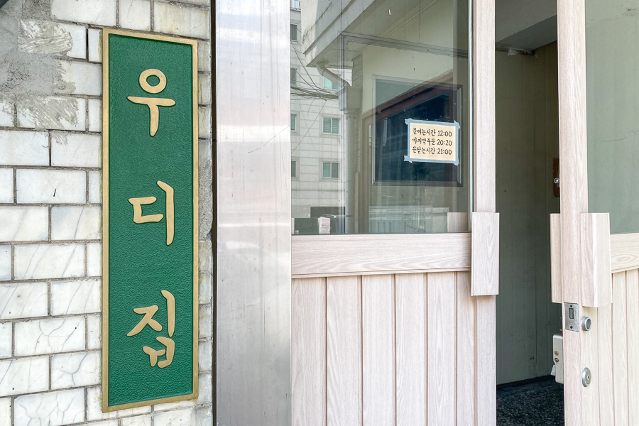 Entrance to Woody Zip with a Korean words (우디집) printed on a green signboard