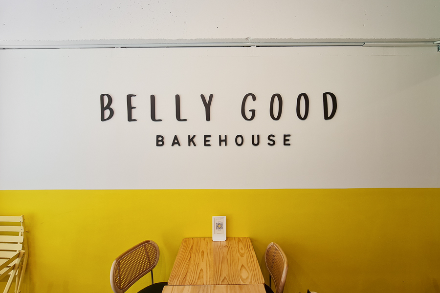 A sign on the wall that says Belly Good Bakehouse
