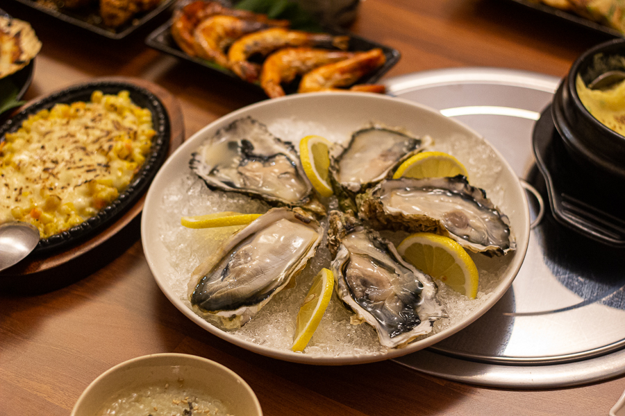 a plate of fresh oysters with lemon slices on the side