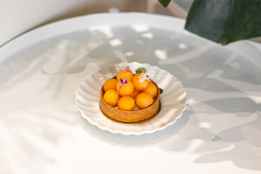 A pistachio musk melon tart with small balls of melon on top