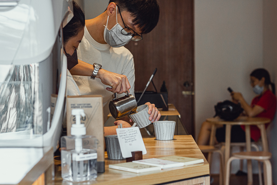 A barista making coffee with latte art