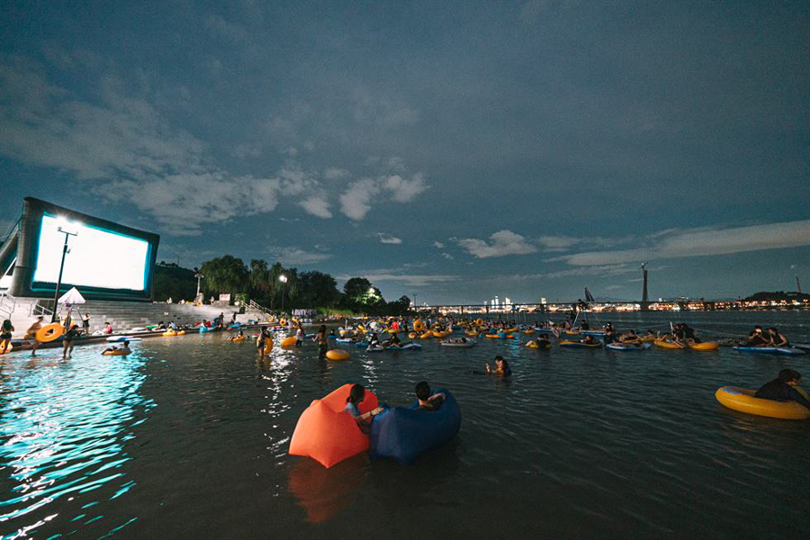 A panorama of people watching an outdoor movie in the sea at the Hangang River Festival in Seoul, South Korea