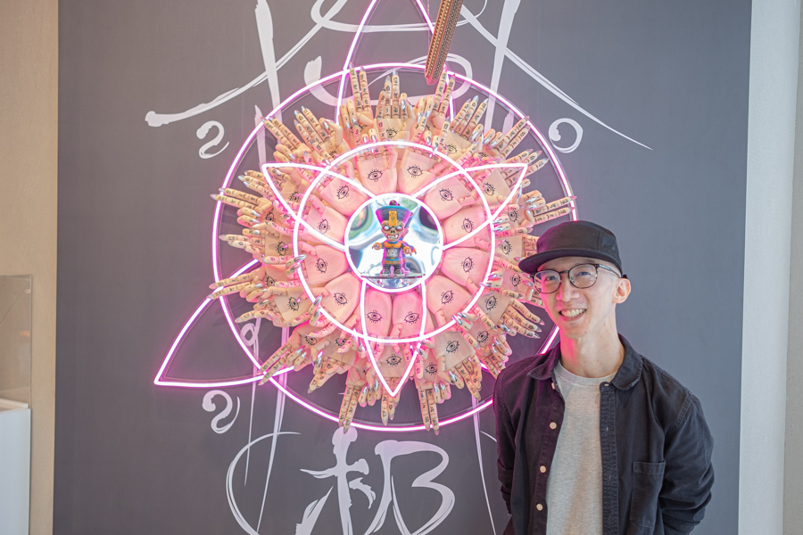 Singaporean artist Daniel Yu beside his work, the BLAXK x Daniel Yu Jiangshi Junior figurine 