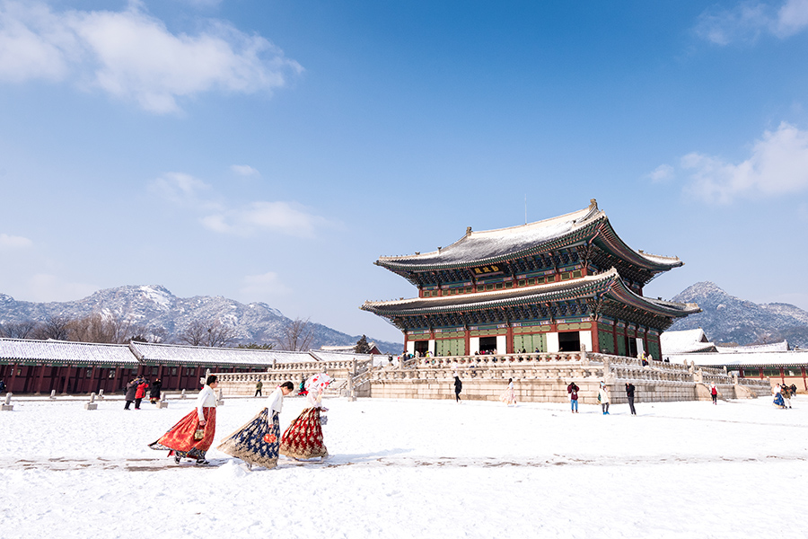 Seoul, South Korea - February, 2017: Gyeongbokgung palace in winter and girls in Hanbok clothes.