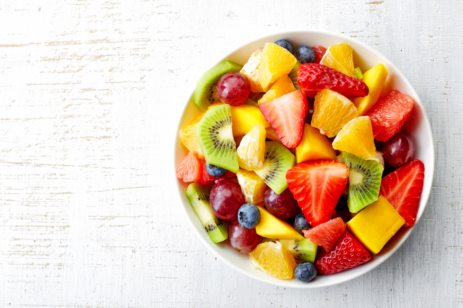 Bowl of healthy fresh fruit salad with watermelon, strawberries, grapes, kiwi and pineapple