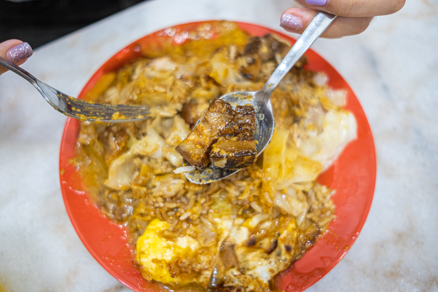 A plate of Hainanese scissors cut curry rice with braised pork belly