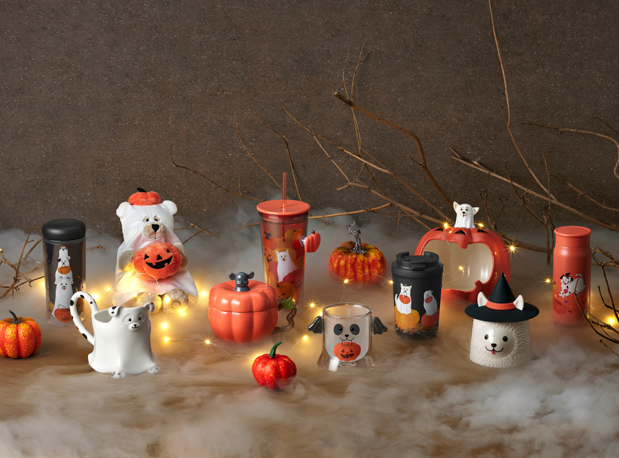 Family collection of Halloween-themed merchandise with string lights and fog. Includes mugs, tumblers, and cups.