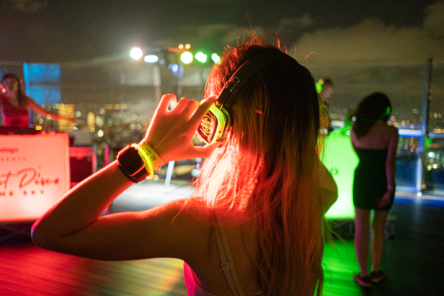 The backview of a female partygoer with headphones at the Silent Disco
