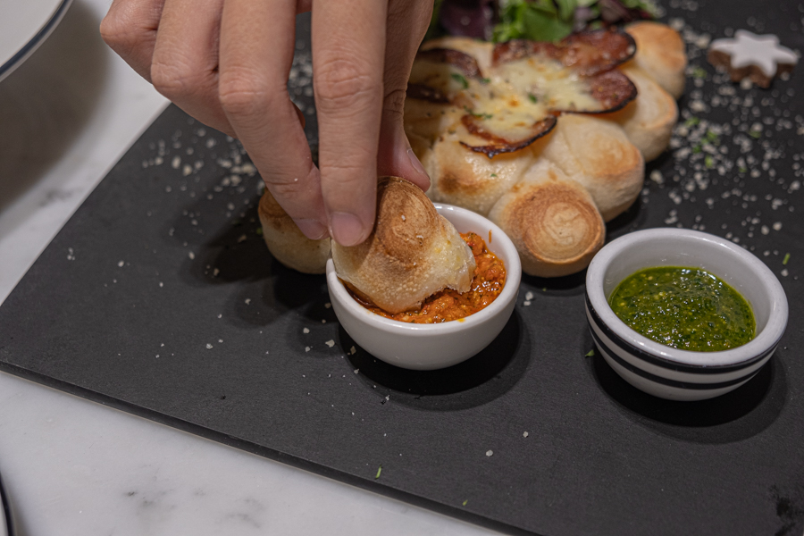 Dough balls from the Christmas Tree Doppio being dipped into sauces
