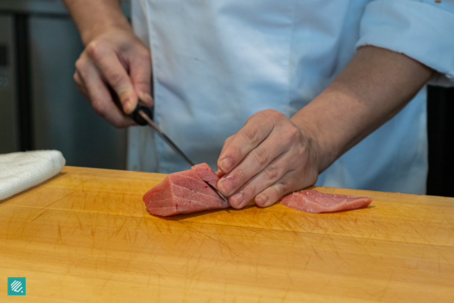 Sushi chef cutting tuna