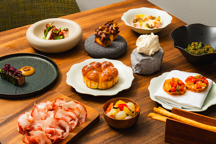 A table filled with dishes from Assaggi Singapore ranging from starters to pasta and mains