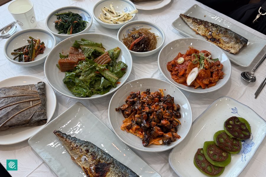 A table full of food featuring items like Lotus Leaf Rice from Sabihyang (사비향) in Buyeo, Chungcheongnam-do